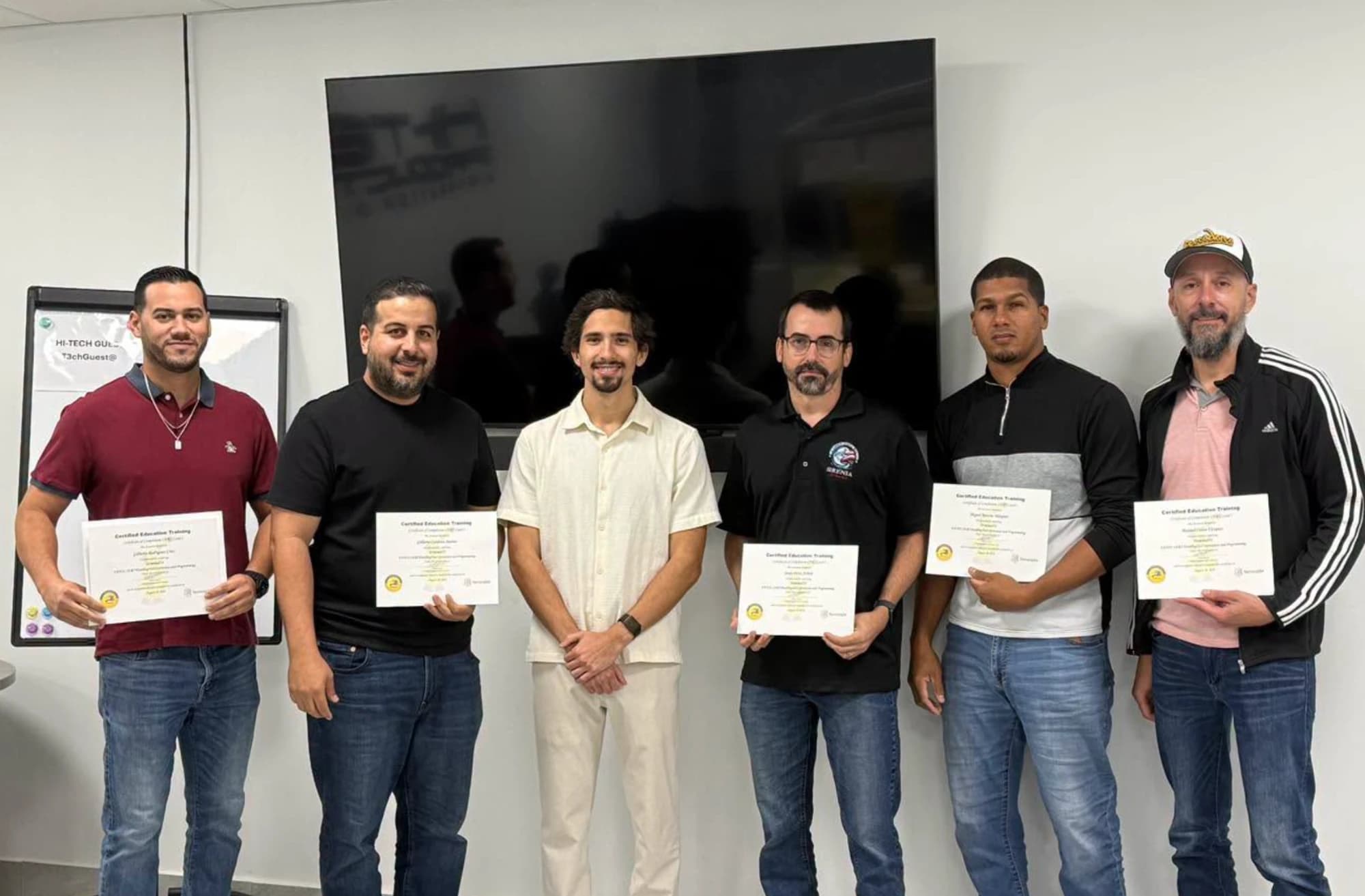 Seis participantes del curso de Robótica Industrial FANUC con su instructor, mostrando sus certificados